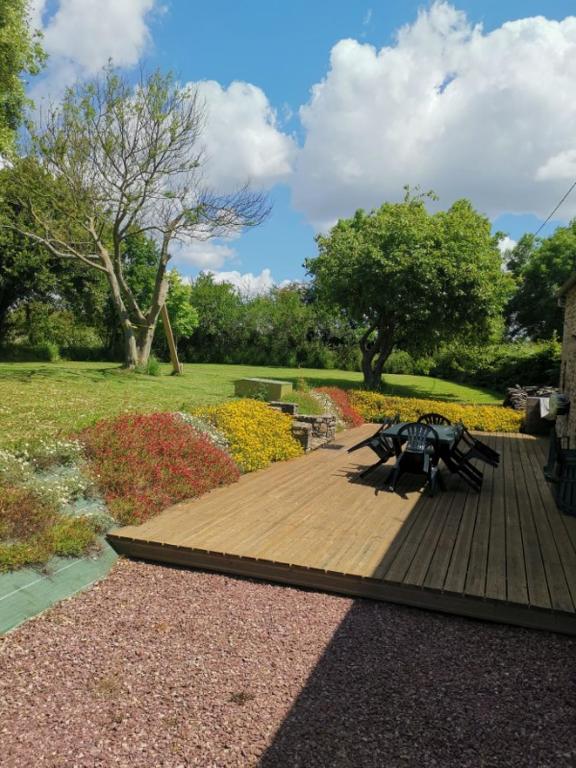 une terrasse en bois avec des tables de pique-nique dans un parc dans l'établissement Maison au bord de la mer, à Bretteville-sur-Ay