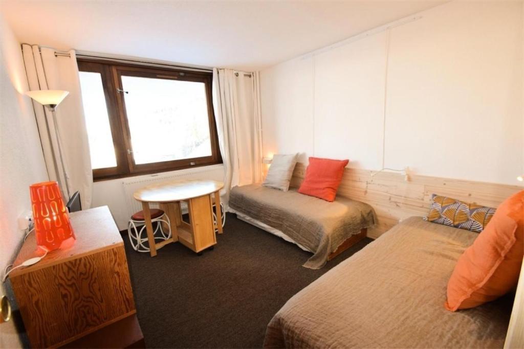 une chambre d'hôtel avec deux lits et une fenêtre dans l'établissement Résidence Le France - Studio pour 3 Personnes 324, à Aime La Plagne