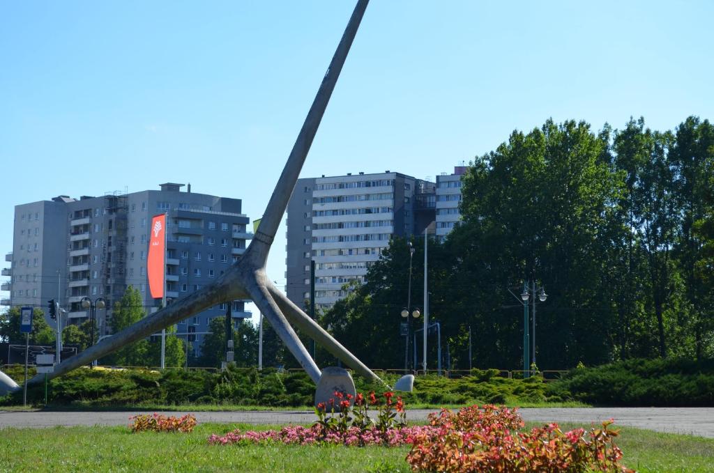 una escultura en un parque con edificios en el fondo en Apartment Silesia Park - Free Parking - easy check-in, en Katowice