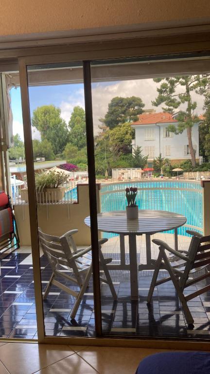 a table and chairs on a balcony with a view of a pool at Casa Margot in Sanremo