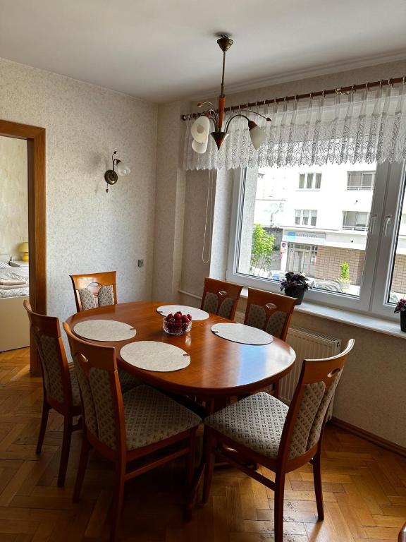 a dining room with a wooden table and chairs at Apartament Gdynia Centrum in Gdynia