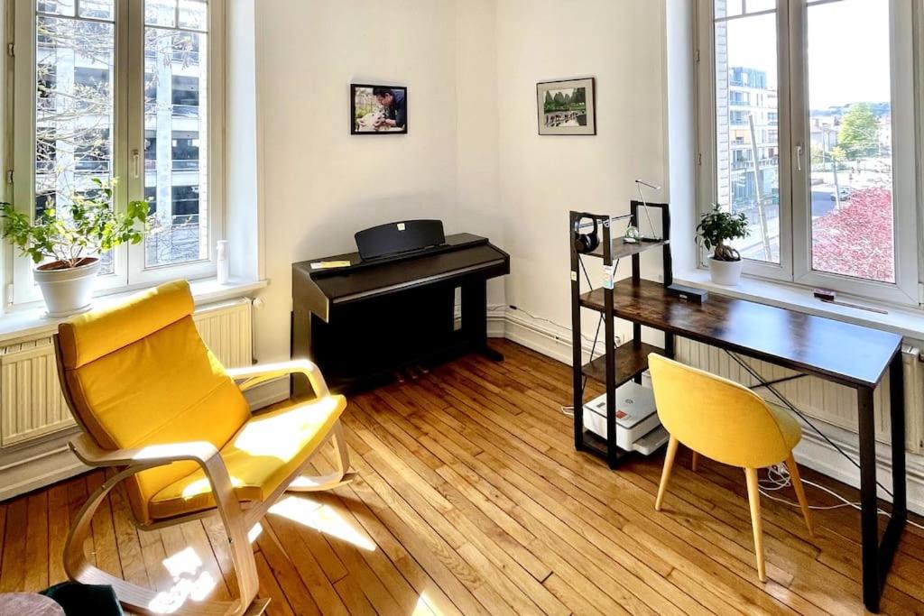 - un bureau et deux chaises dans une pièce avec un piano dans l'établissement Charmant appart proche Stanislas, à Nancy