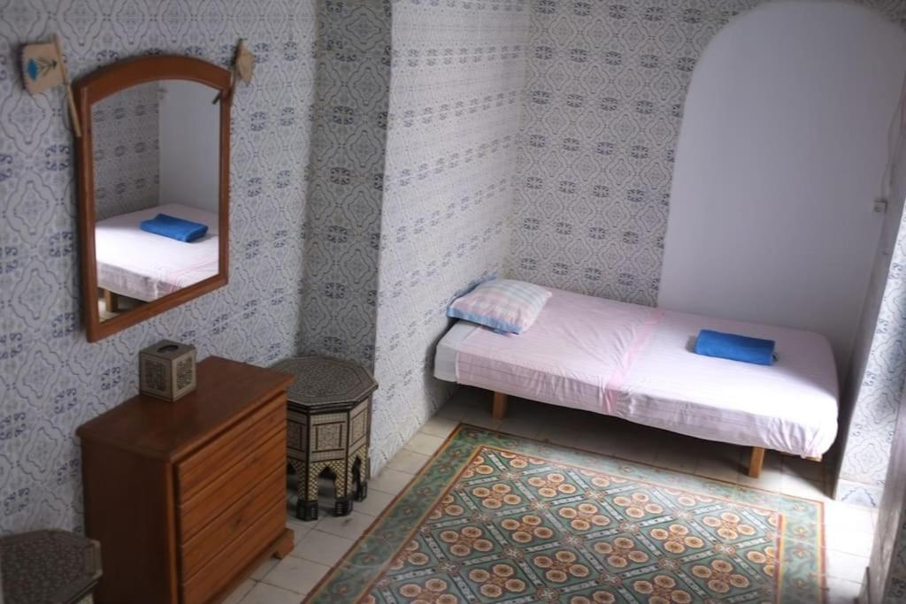 突尼斯Belle maison dans la Médina的有两张床和一面镜子的小房间
