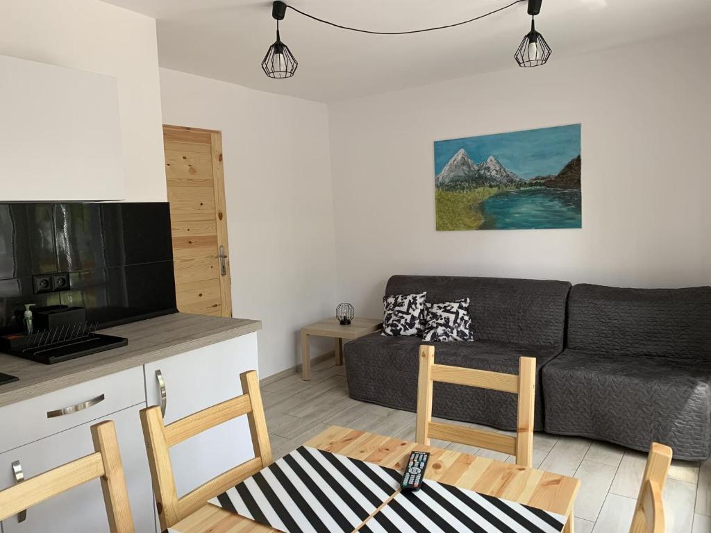 a living room with a couch and a table at Apartamenty Trawers in Wielen Zaobrzanski