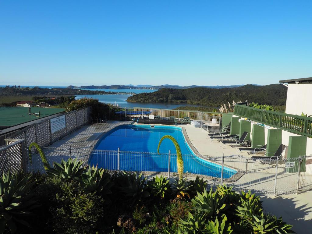 a swimming pool with a view of a river at Cook's Lookout Motel in Paihia