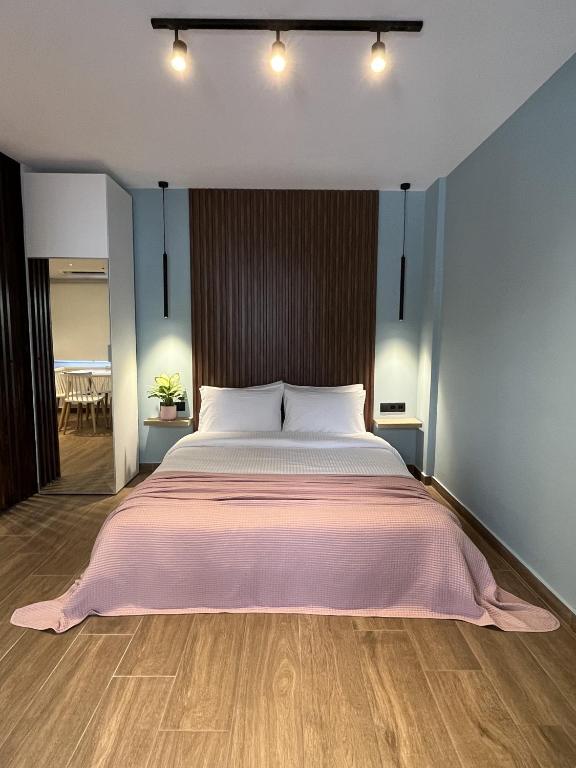 AnemómylosKalynthia House的卧室里有一张大床，上面铺着粉色毯子