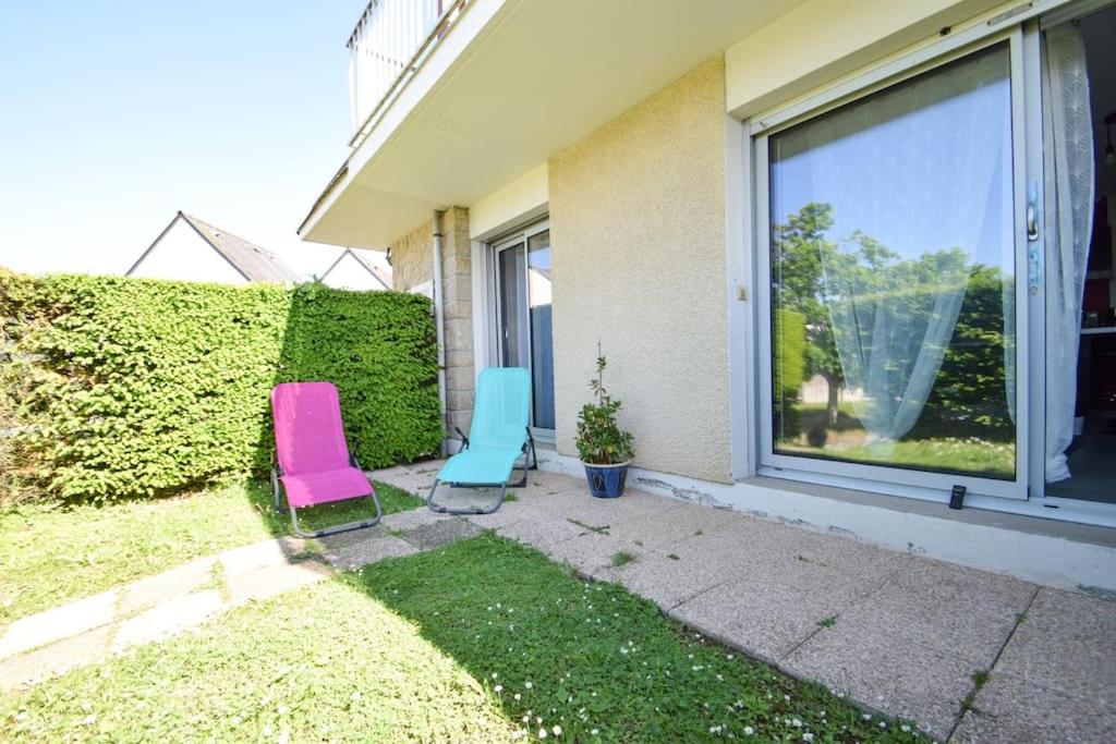 deux chaises assises dans l'herbe à l'extérieur d'une maison dans l'établissement Appt 4 pers à 400m plage avec jardin, à Dinard