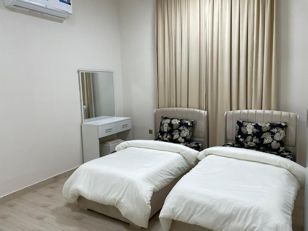 a room with two beds and a mirror at شقق مفروشة صلالة - Furnished Apartments Salalah in Salalah