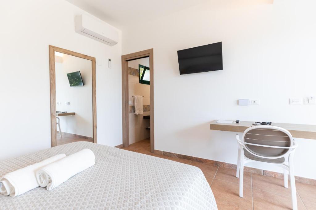 a bedroom with a bed and a desk and a television at Hotel MARINELLA parking wi-fi spiaggia attrezzata in Capo Vaticano