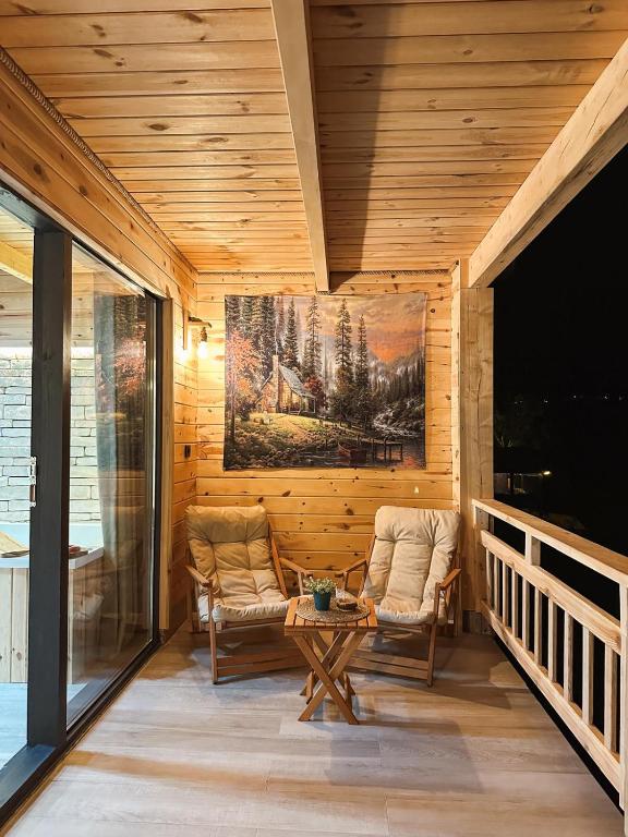 a room with two chairs and a table on a porch at Dağhan Bungalov in Çamlıhemşin