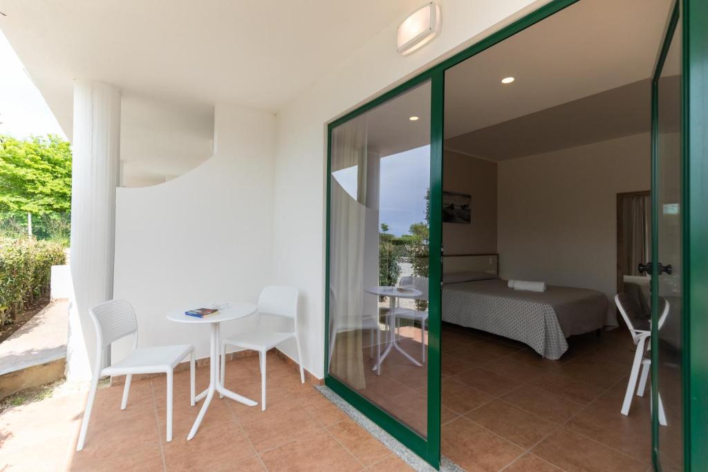 a room with a table and chairs and a bed at Hotel MARINELLA parking wi-fi spiaggia attrezzata in Capo Vaticano