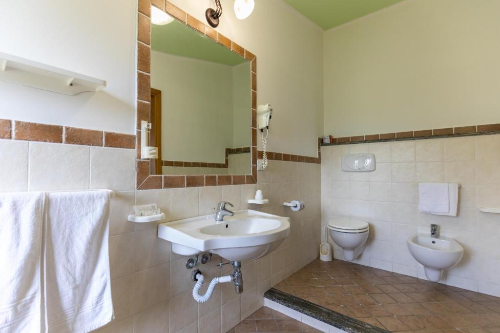 a bathroom with a sink and a toilet and a mirror at Hotel MARINELLA parking wi-fi spiaggia attrezzata in Capo Vaticano