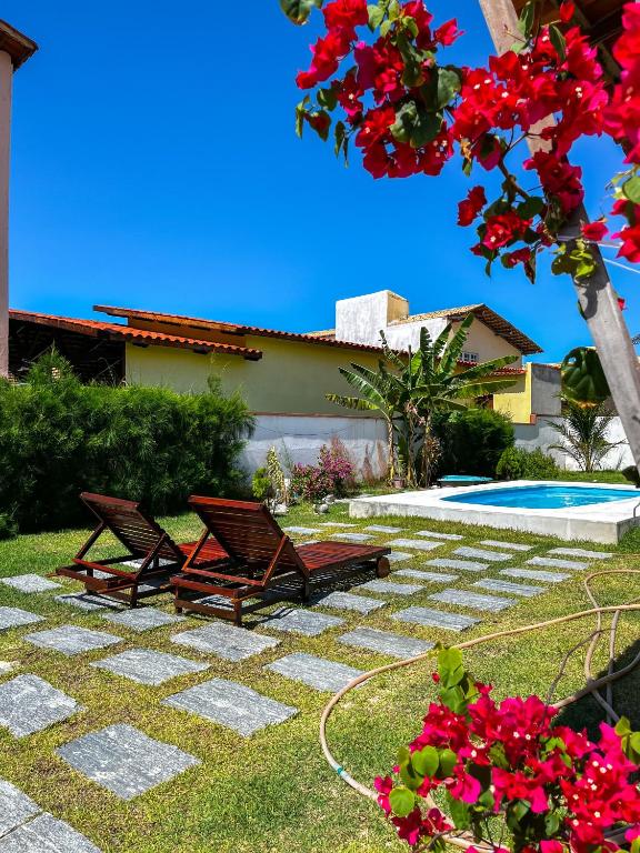 a patio with two chairs and a swimming pool at Casa Egípcia em Morro branco - na quadra da praia in #N/A