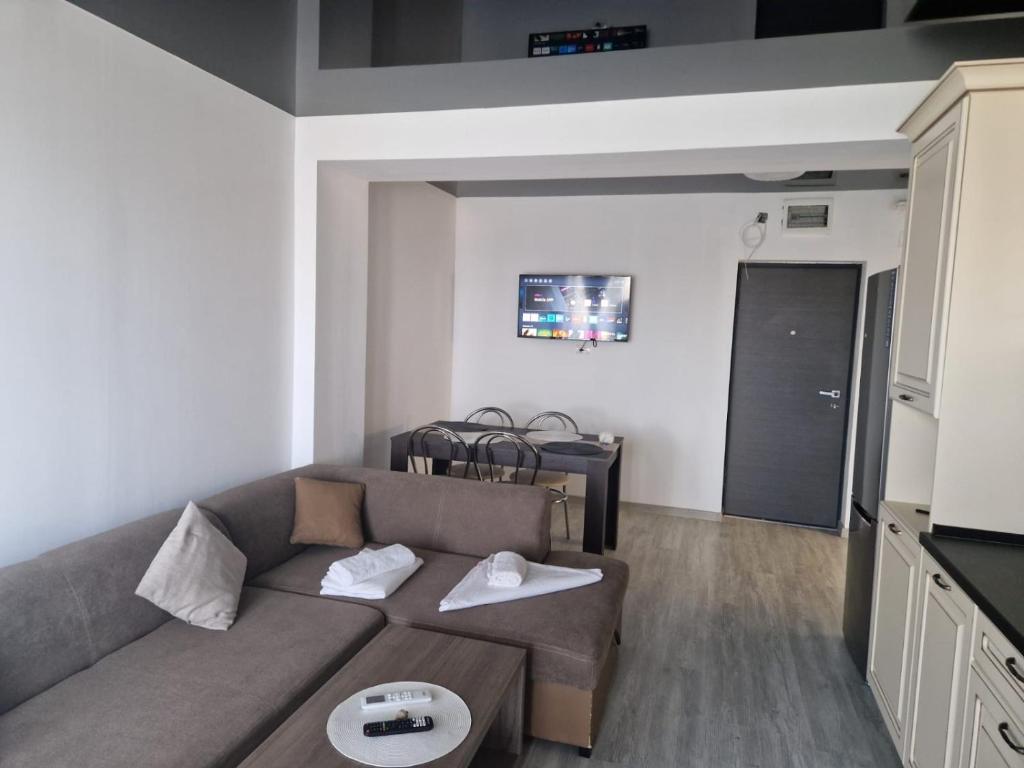 una sala de estar con un sofá y una mesa en Sun up Mamaia nord, en Năvodari