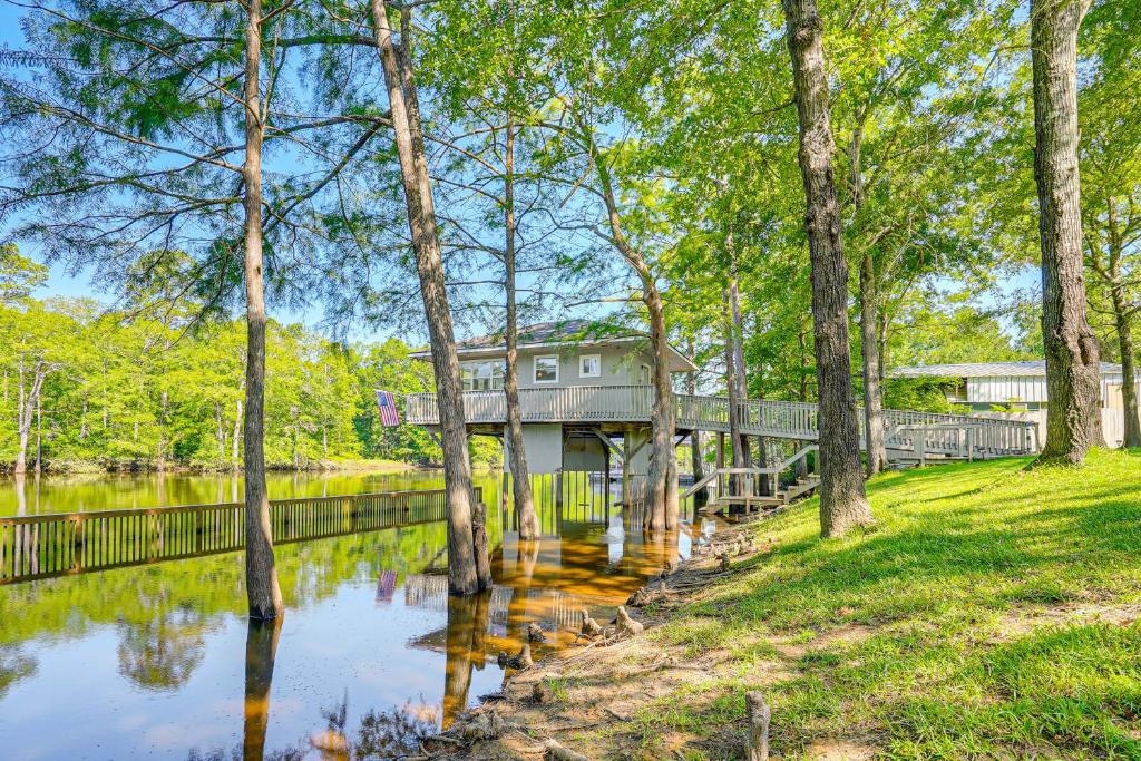 a house on a bridge over a river with trees at Private Boat Launch! Riverfront Jefferson Retreat in Jefferson
