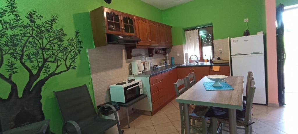a kitchen with a table and a tree mural on the wall at Politimis house in Makrinára