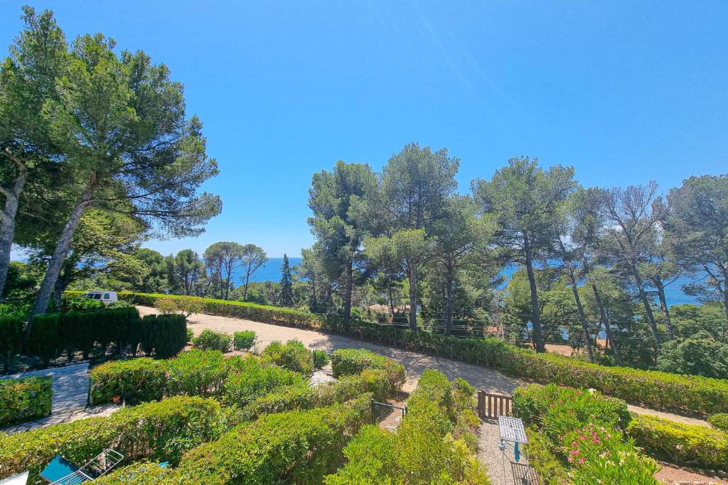 un jardin avec des haies et des arbres par beau temps dans l'établissement Seafront apartment 4 people in domain - 2 Pools, à Saint-Raphaël