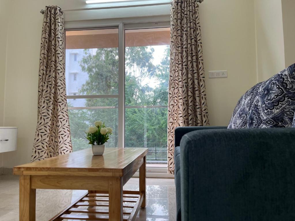 a living room with a couch and a table and a window at SSN Home Stays in Bangalore near PLAY Arena in Bengaluru
