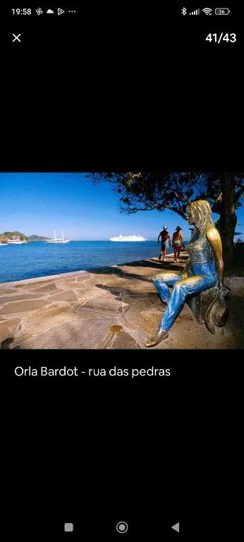 a statue of a woman sitting on a bike near the water at Búzios Beach Resort Residencial 1322 in Búzios