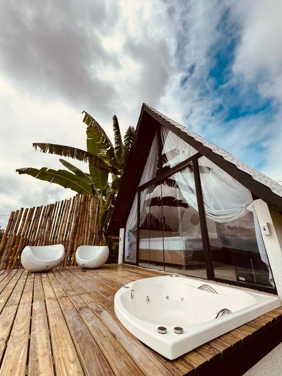 a bathroom with a bath tub on a wooden deck at Rancho Navarro - Cabana A-Frame in Pôrto de Pedras