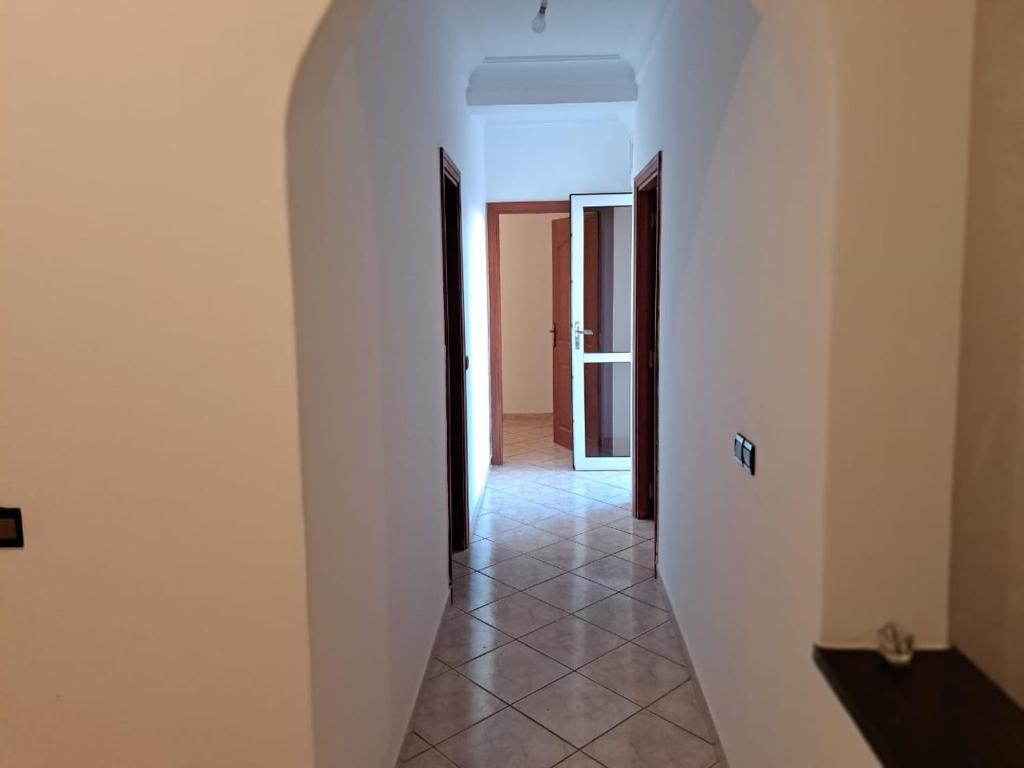 a hallway with white walls and a tile floor at Vue sur mer in El Harhoura