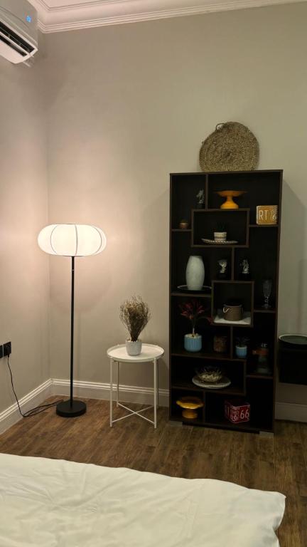 ein Zimmer mit einem Bett und einem Tisch und einem Bücherregal in der Unterkunft ستديو in Riad