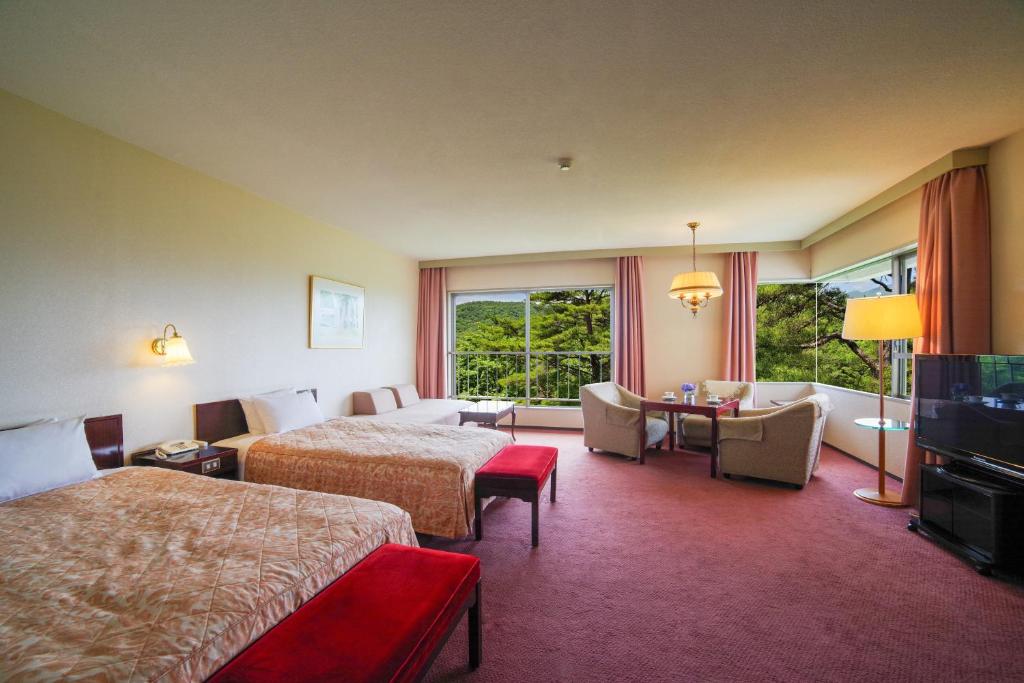 Postel nebo postele na pokoji v ubytování Tsumagoi Prince Hotel