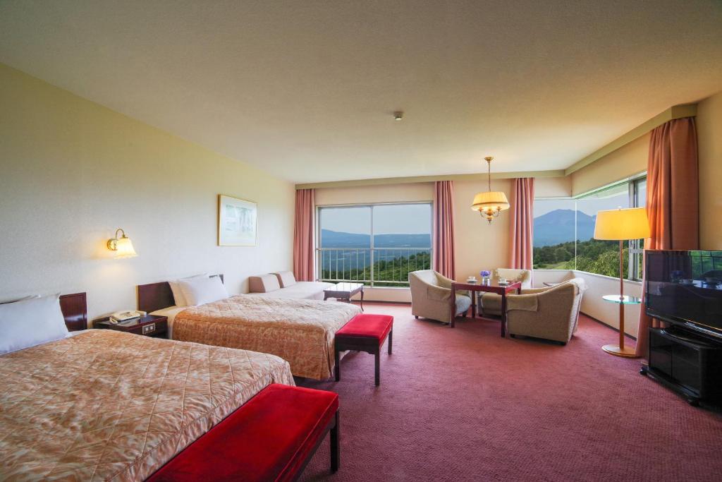 Postel nebo postele na pokoji v ubytování Tsumagoi Prince Hotel