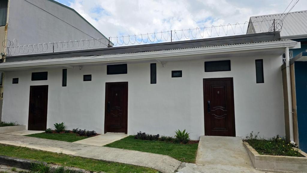 a white house with two doors and grass at BnB Ecostay in San José