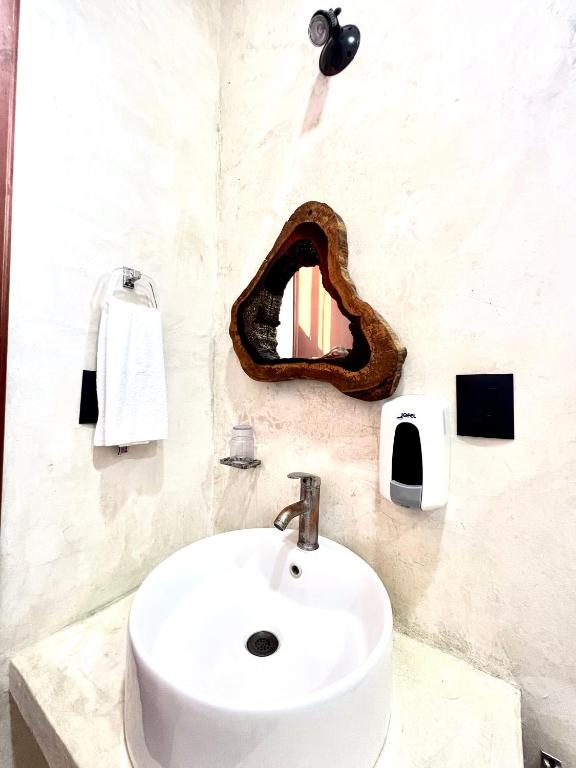 Un baño con un lavabo y un espejo en la pared. en Kin studios holbox, en Isla Holbox