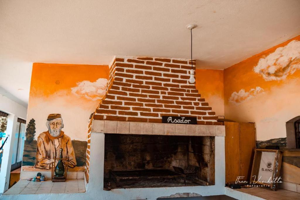- un salon avec une cheminée en briques et un tableau dans l'établissement El kincho hostel bike, à La Cruz