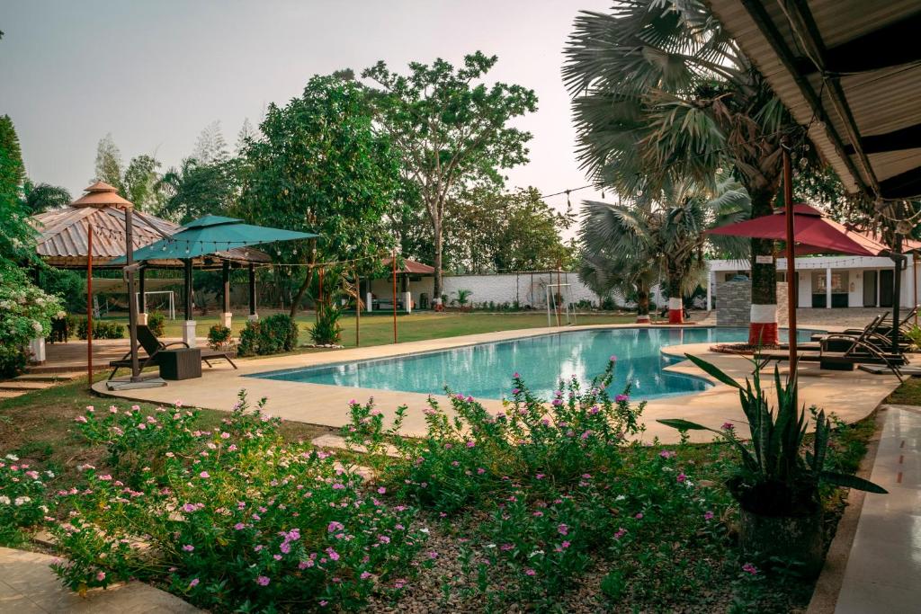 a swimming pool in a yard with trees and flowers at Villa para descanso en Familia Uso exclusivo in Puerto Caldas