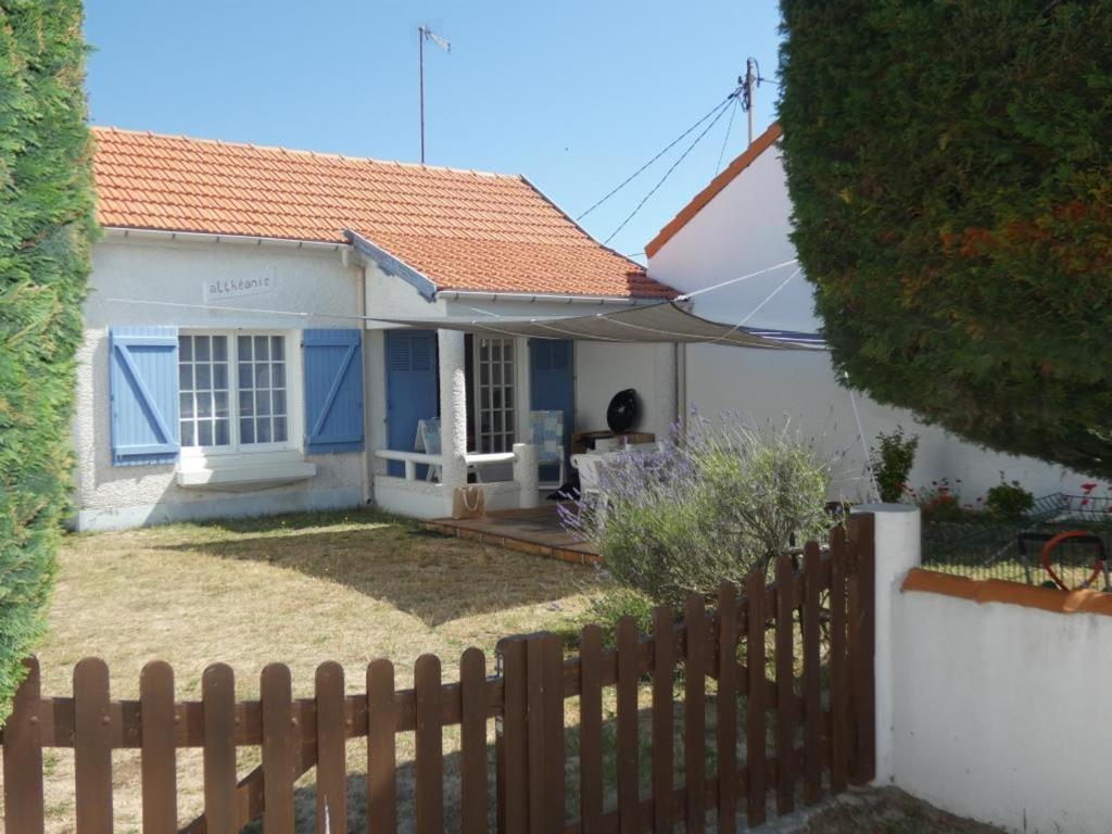 une maison blanche et bleue avec une clôture en bois dans l'établissement Maison de vacances à Notre-Dame-de-Monts, proche plage, jardin, 6 pers, animaux permis - FR-1-540-283, à Notre-Dame-de-Monts
