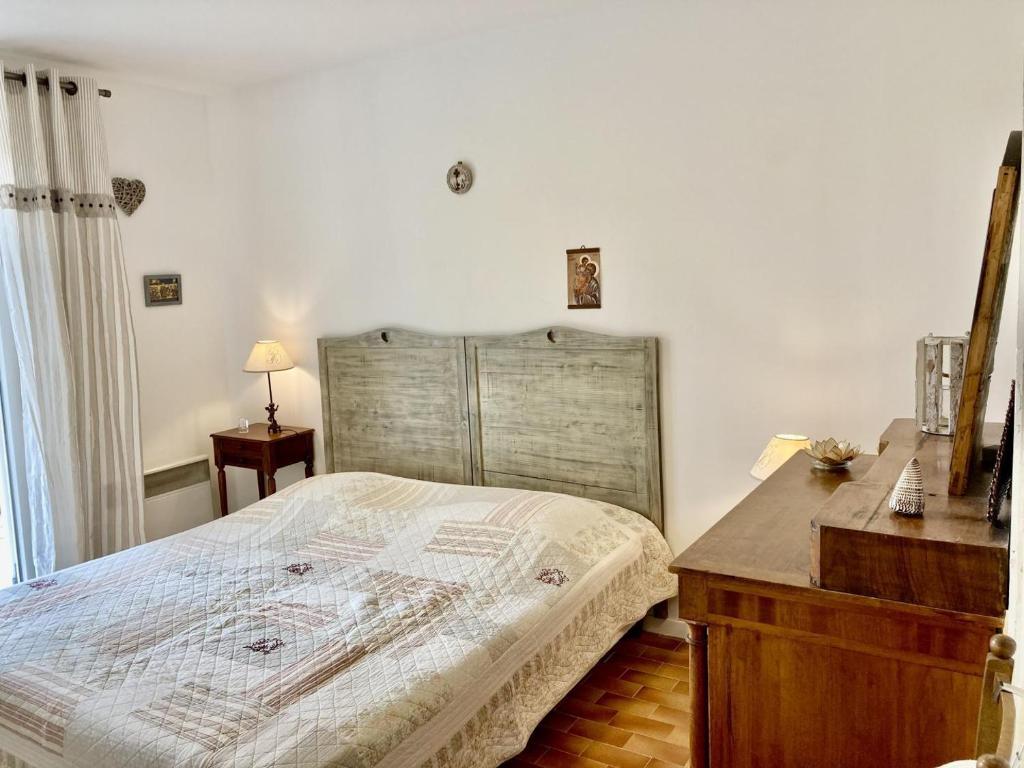 a bedroom with a bed and a wooden dresser at Villa hortus mariae in Le Thoronet