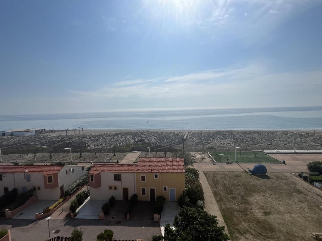 - une vue sur une maison avec l'océan en arrière-plan dans l'établissement Appartement T2 Cabine Mezzanine avec Parking à 50m de la Plage - FR-1-799-23, au Barcarès