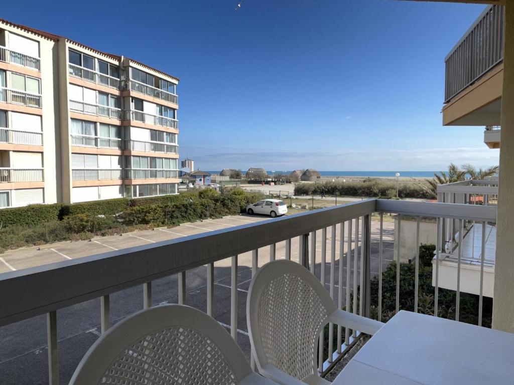 - un balcon avec une table, des chaises et une voiture dans l'établissement T2 au Barcarès - Accès direct plage, proche port, parking sécurisé - FR-1-799-19, au Barcarès