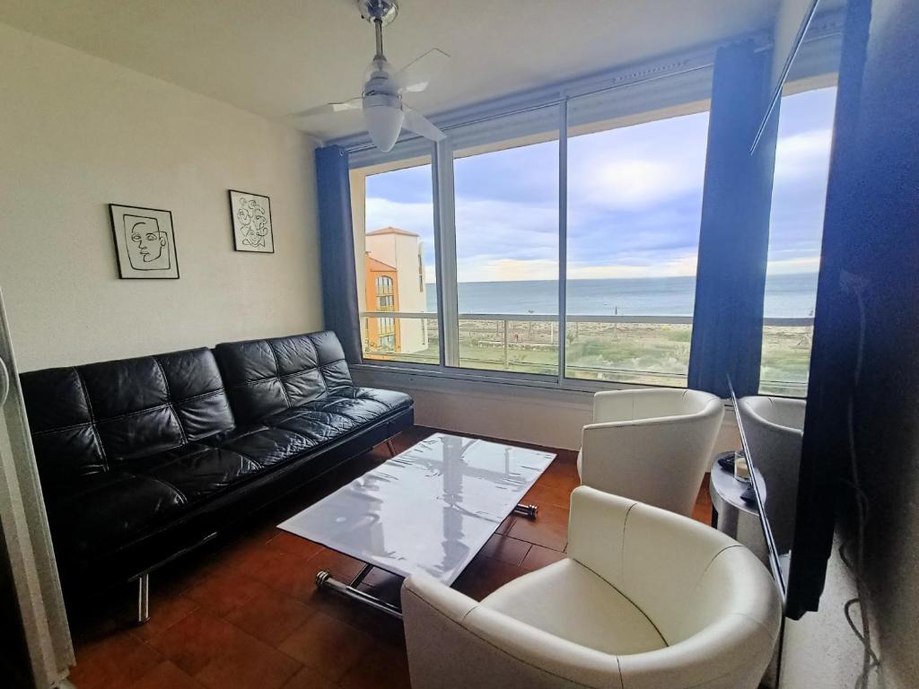 un salon avec un canapé, une table et des chaises dans l'établissement Le Barcarès : T2 tout confort avec parking privé, animaux admis - FR-1-799-44, au Barcarès