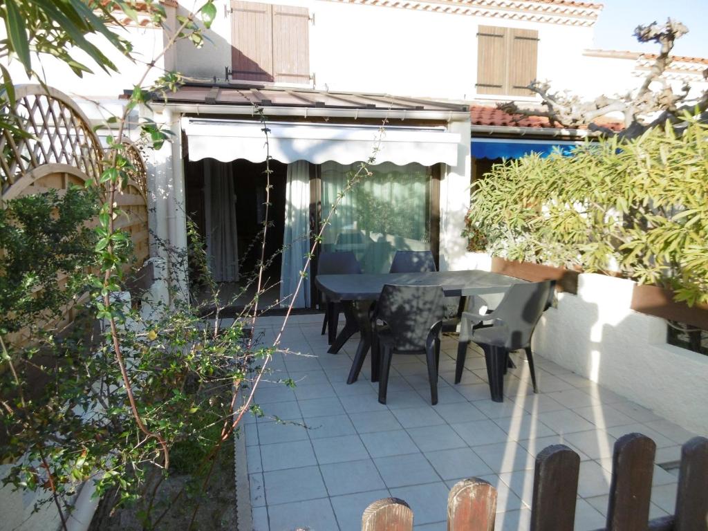 a patio with a table and chairs on it at Le Barcarès - Villa T3 Coquette - Résidence Calme - Proche Plage, Port, et Village - Parking Privé - FR-1-799-38 in Le Barcarès