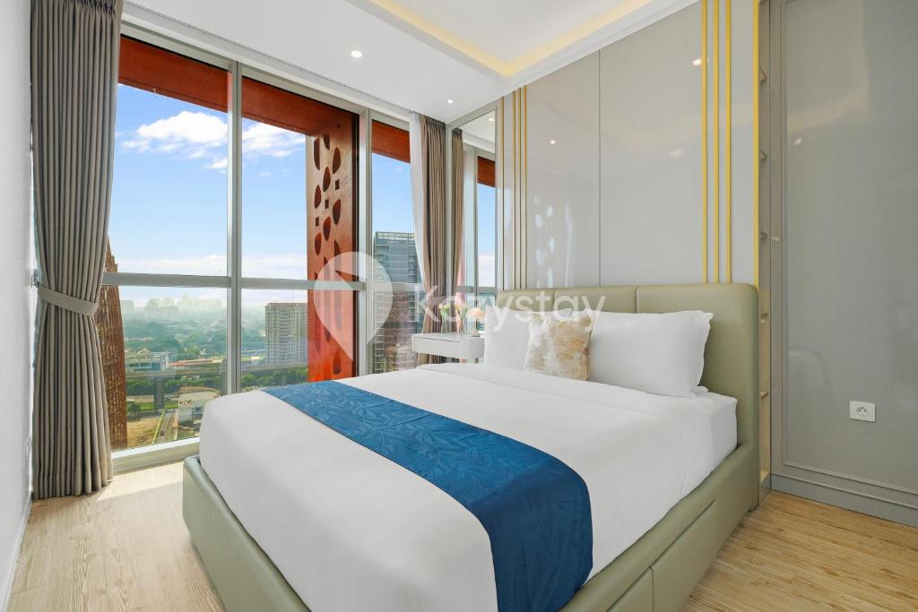 a bedroom with a large bed with a large window at Altin by Kozystay - TB Simatupang in Jakarta