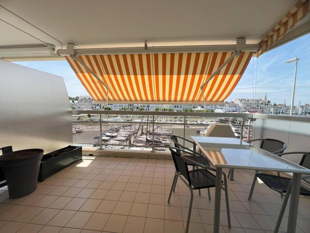 un balcon avec une table et des chaises et une vue sur un port dans l'établissement La Baule: Bel appartement à 250m de la plage et des commerces - FR-1-392-238, au Pouliguen