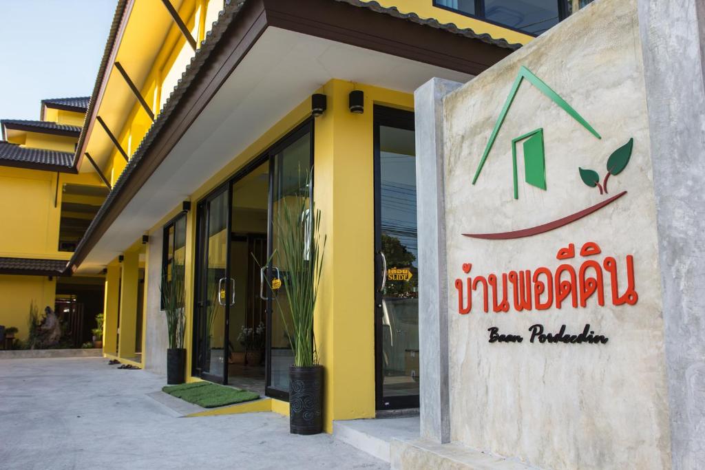 a store with a sign on the side of a building at Baan Pordeedin in Chiang Rai