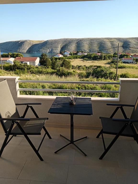 a table and two chairs on a balcony with a view at Apartmani Sol Vlašići in Pag