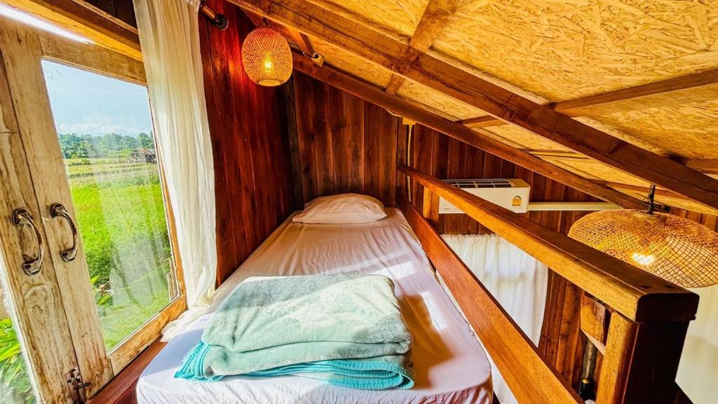 เตียงในห้องที่ DeeTorJai FarmStay Nan ดีต่อใจ ฟาร์มสเตย์ น่าน โดยเจ้าของ