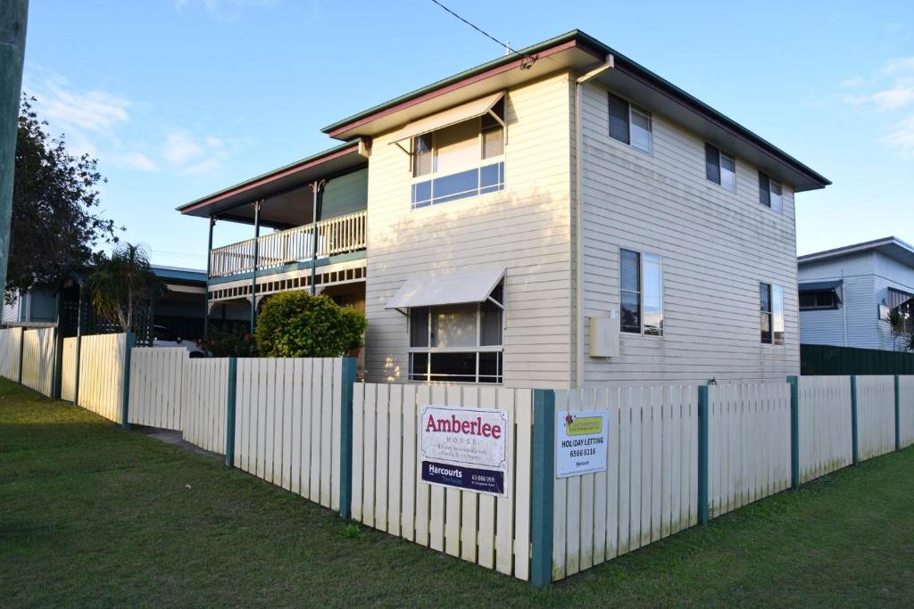 a house with a white fence in front of it at Amberlee House - bring your own linen in South West Rocks