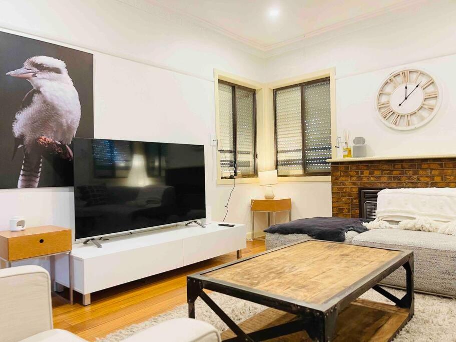 a living room with a large television and a table at D139 Norfolk Cottage Stay in Maribyrnong