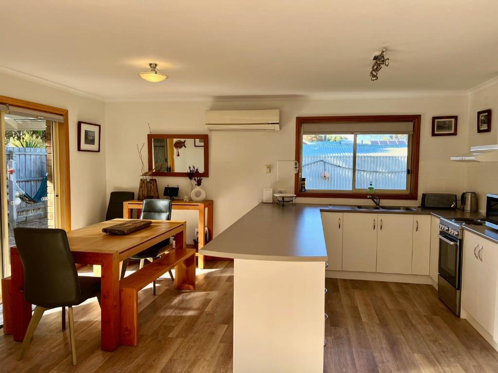 a kitchen with a table and a dining room at Lazy Sails Port - Pets welcome inside WiFi in Robe
