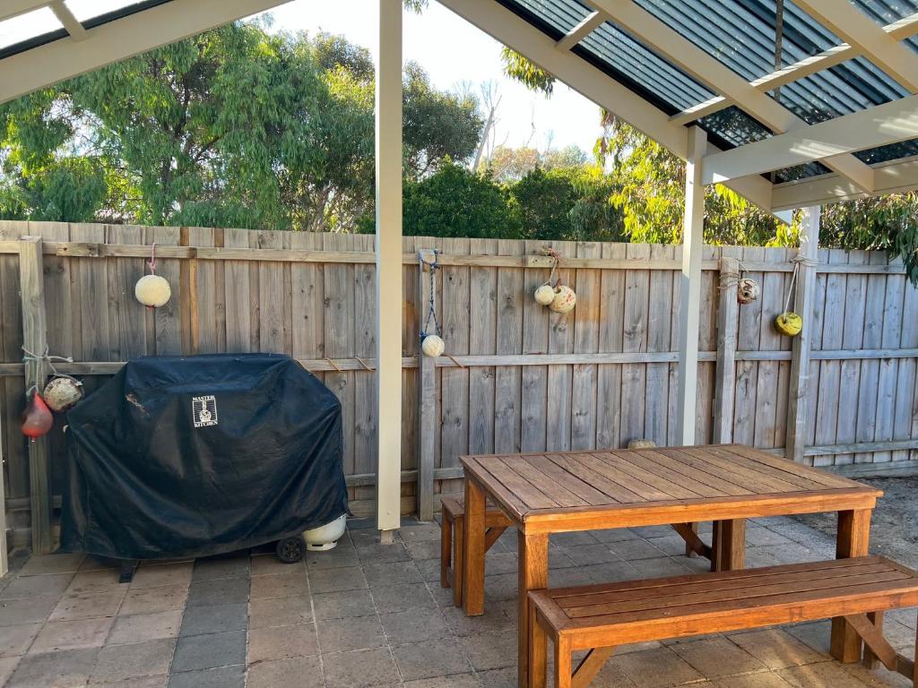 a picnic table and bench under a pergola at Lazy Sails Port - Pets welcome inside WiFi in Robe