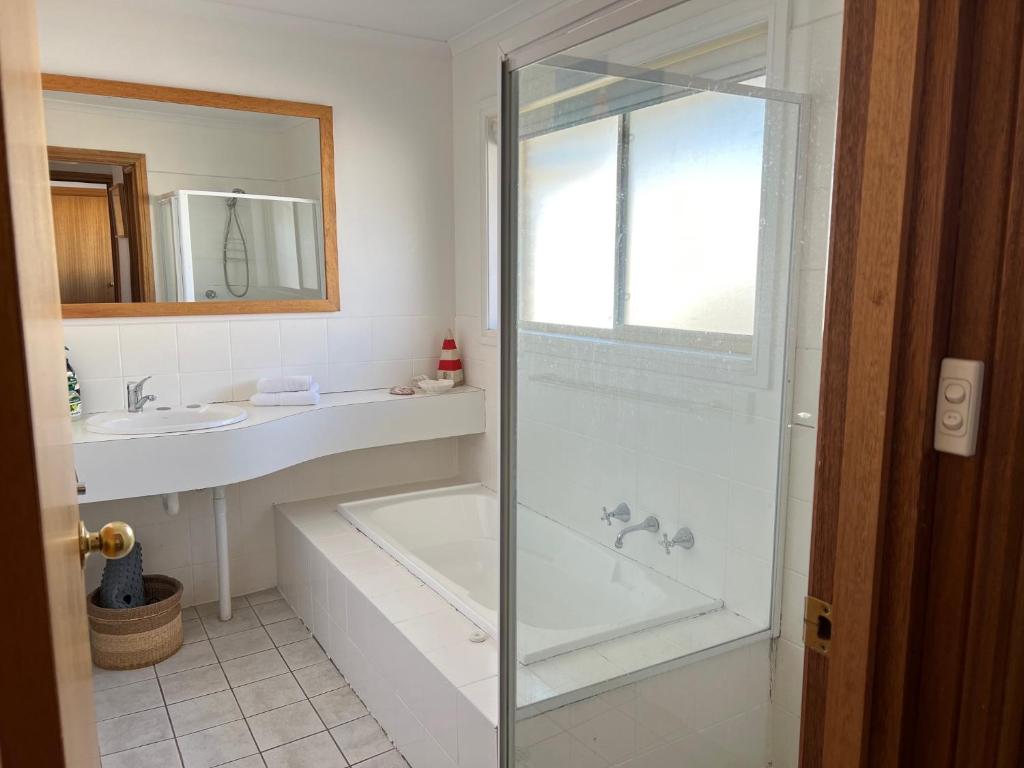 a bathroom with a shower and a tub and a sink at Lazy Sails Port - Pets welcome inside WiFi in Robe