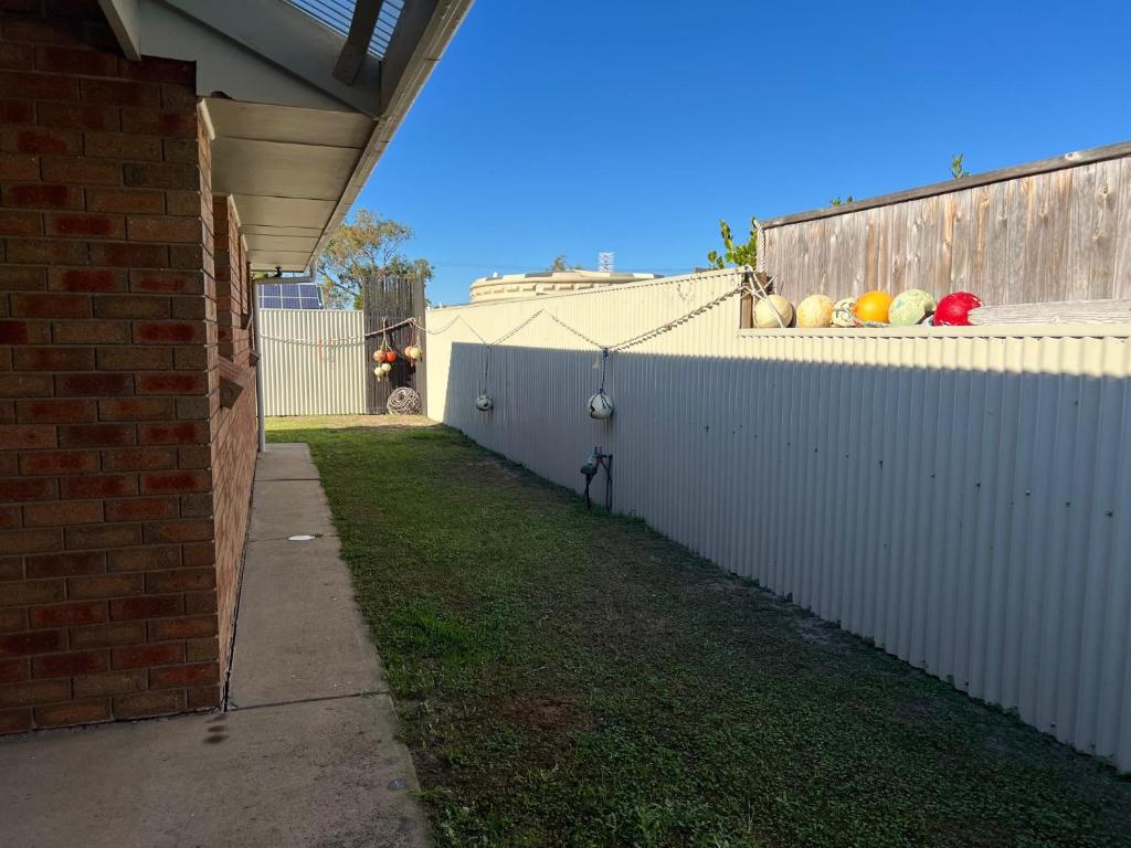 a white fence with fruit on top of it at Lazy Sails Port - Pets welcome inside WiFi in Robe