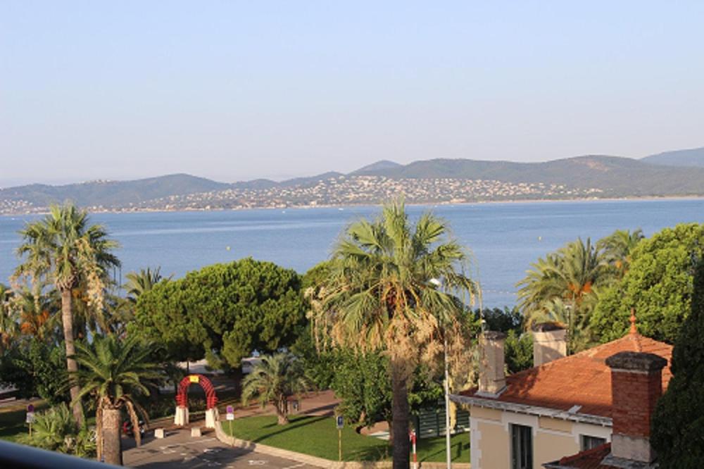 - une vue sur une grande étendue d'eau avec des palmiers dans l'établissement beaurivage, à Saint-Raphaël